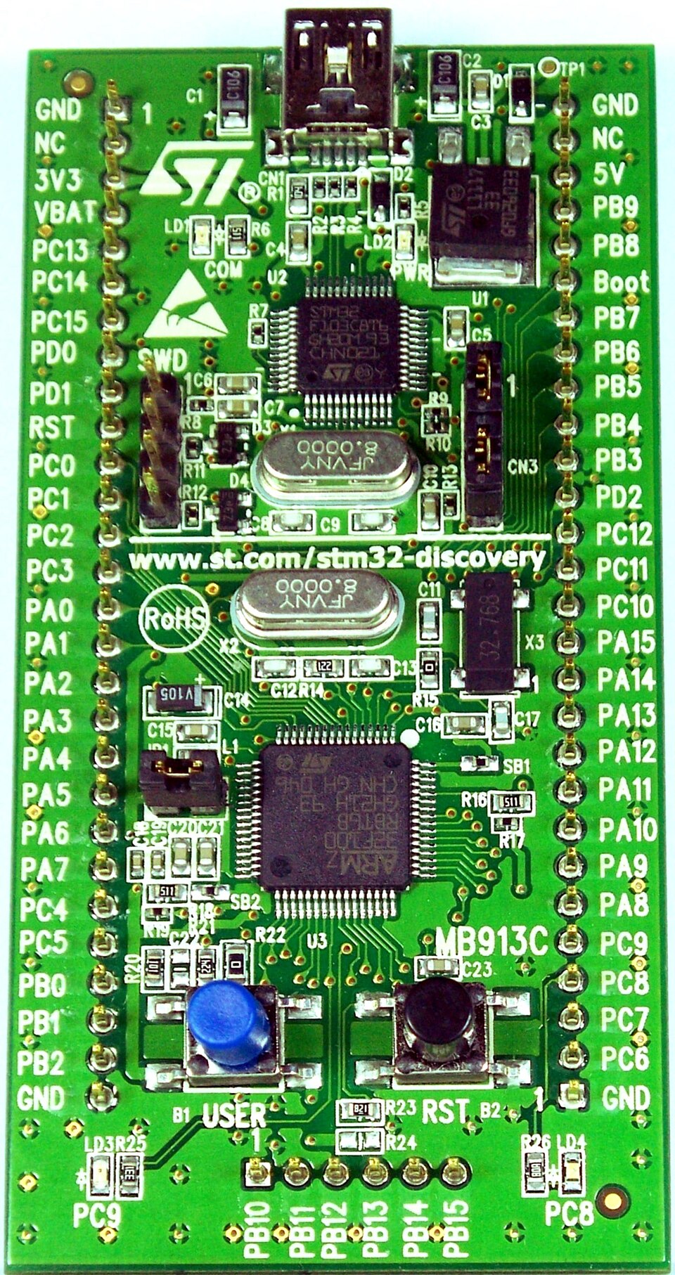 An STM32 Discovery evaluation board, an STMicroelectronics Cortex-M microcontroller at its center with the SWD debug header above it.