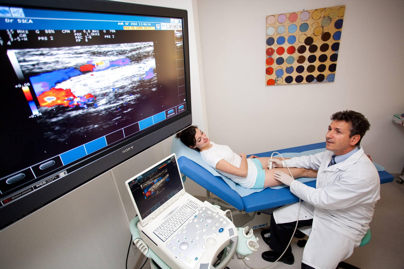 A vascular color-Doppler ultrasound scan in progress, probe in the clinician's hand