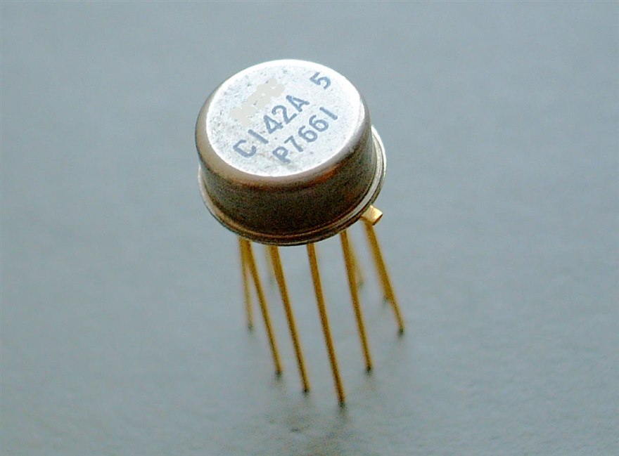 A metal-can analog integrated circuit with gold leads, marked C142A, the kind of op-amp-class part used in a precision signal chain.
