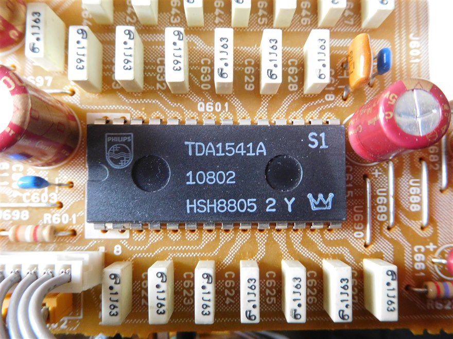 A Philips TDA1541A data converter chip in a DIP package on a circuit board, ringed by film capacitors.