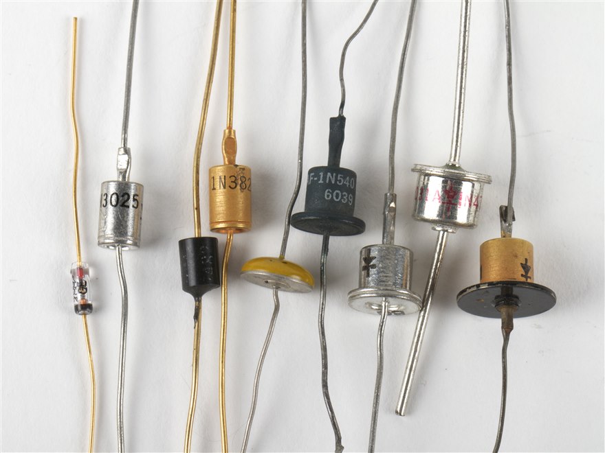 An assortment of axial through-hole diodes in metal and epoxy packages, several with part numbers visible.