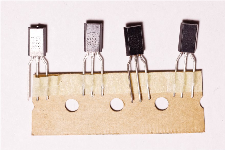 Several small-signal transistors in TO-92 packages on a tape-and-reel strip.