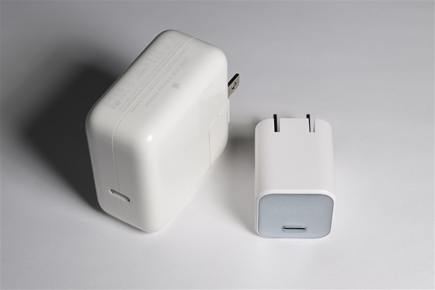 A large silicon USB-C charger beside a much smaller GaN charger of the same power rating.