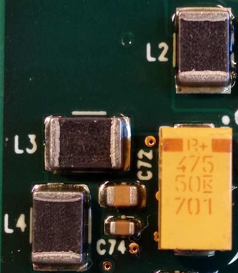 Surface-mount ferrite beads marked L2, L3 and L4 on a circuit board with small decoupling capacitors and a tantalum capacitor beside them.