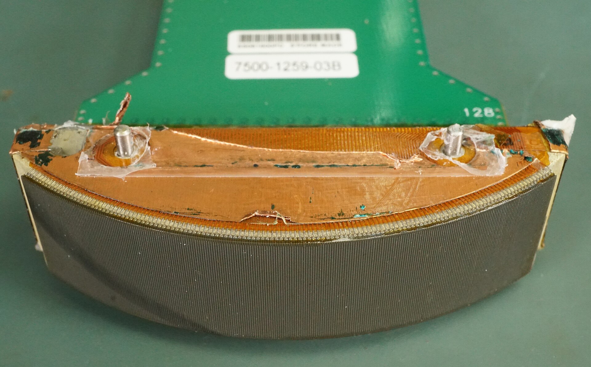 Inside view of a curved array ultrasound probe, showing the curved row of elements and the copper wiring behind it.