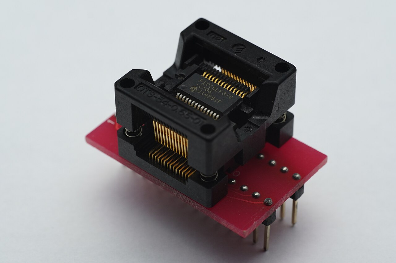 Close-up of a PIC microcontroller marking showing the part number and date code