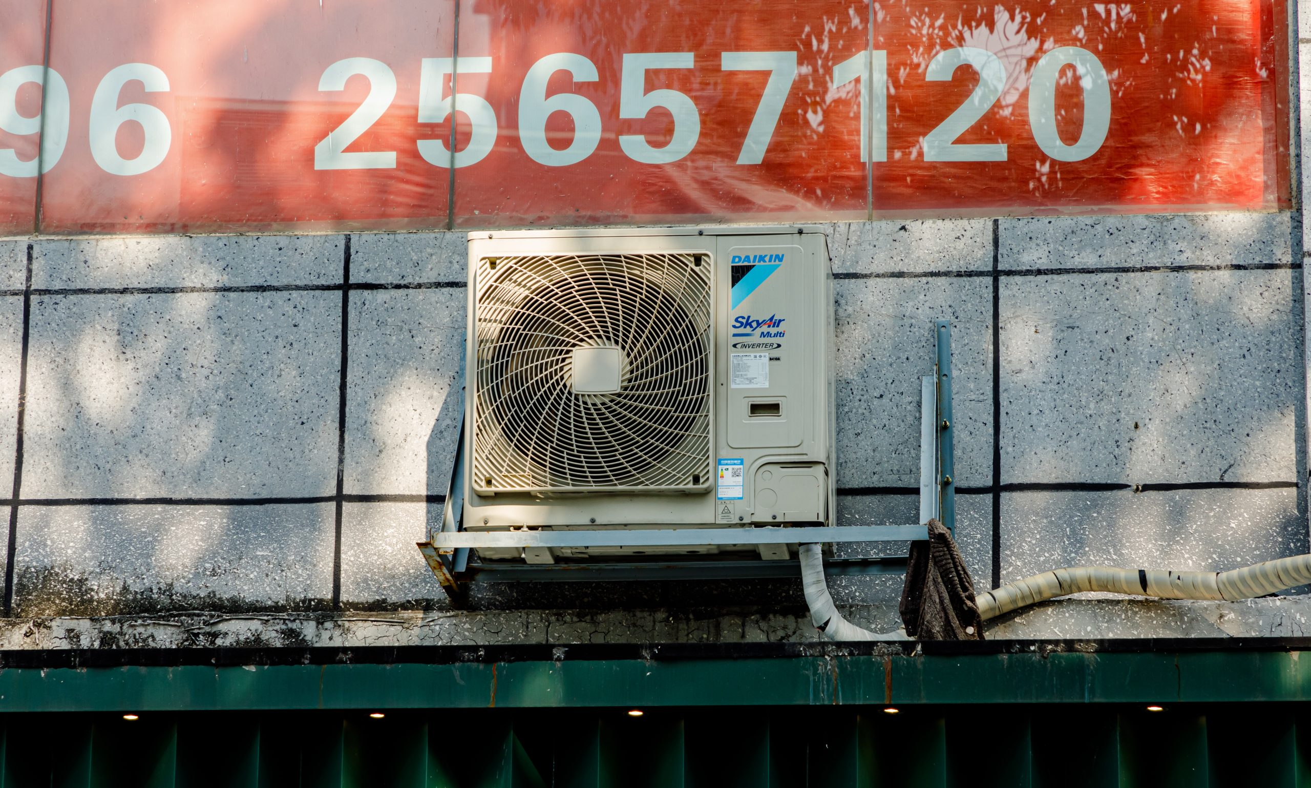 A Daikin air-conditioner outdoor unit mounted beside a building