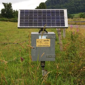 Solar-powered electric fence energizer station on a pasture line