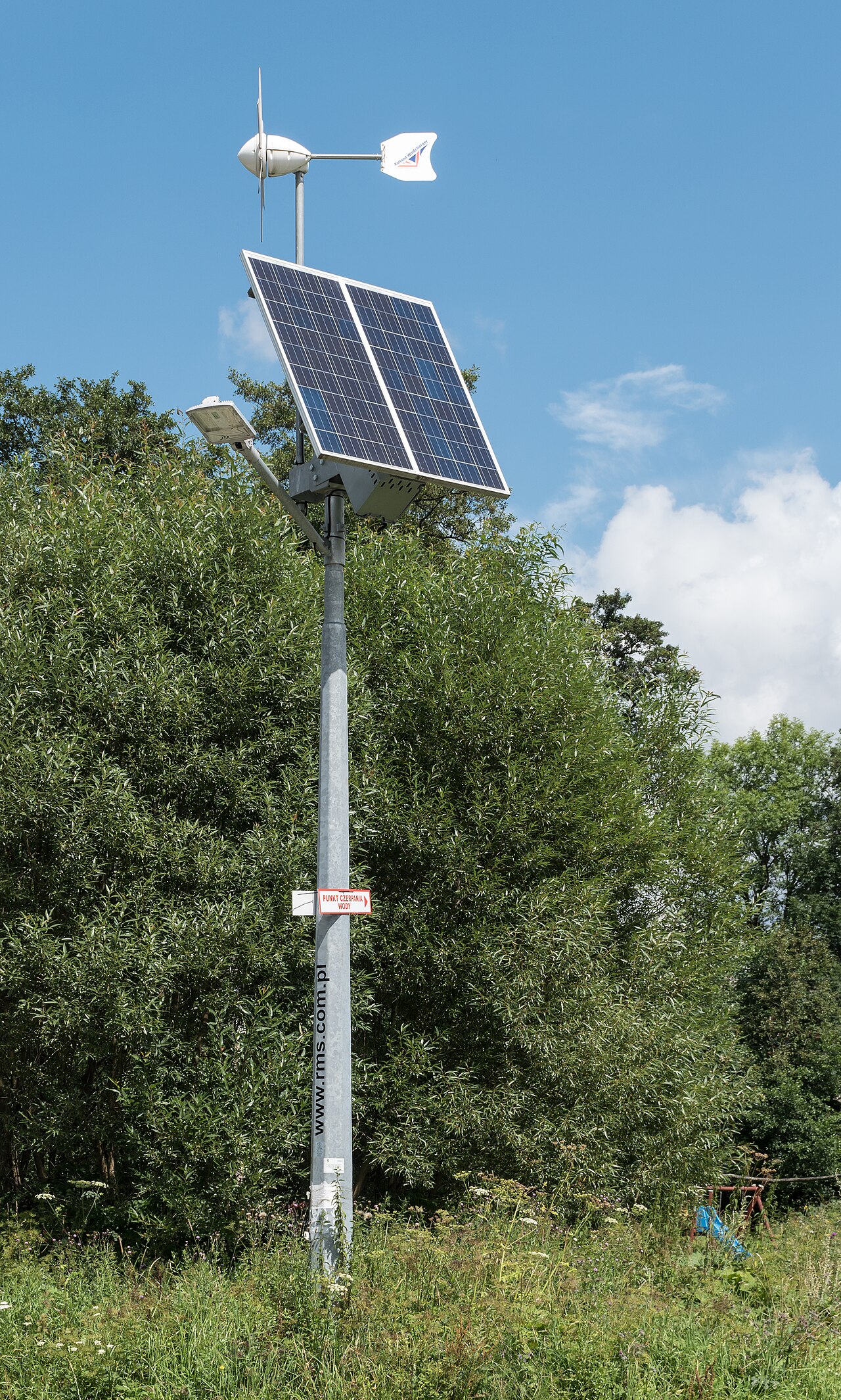 Solar street light pole with twin panels, small wind turbine and LED arm