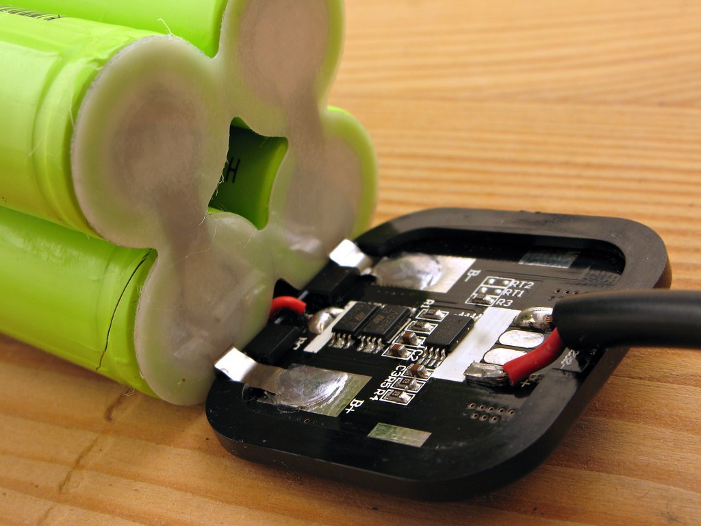 A lithium cell pack with its protection board, showing MOSFETs, nickel strips and thermistor pads