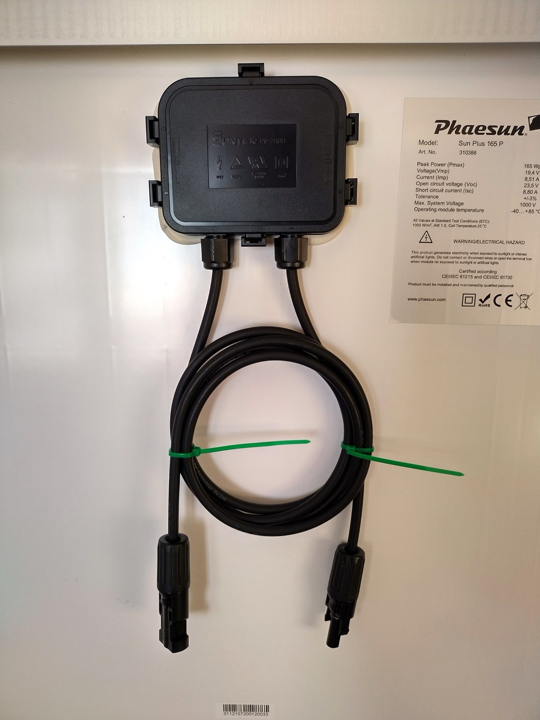Back of a 165 W solar panel: junction box, coiled MC4 leads, and the specification sticker listing Vmp 19.4 V and Voc 23.5 V