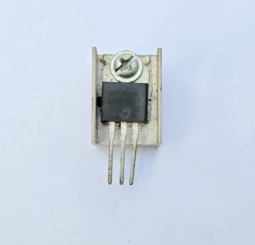 IRF9540N power MOSFET in a TO-220 package bolted to a small aluminium heatsink