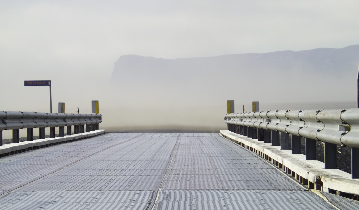 Dust storm crossing a bridge, visibility dropping to a few hundred metres with blowing dust filling the air