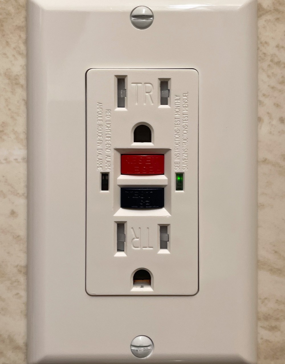 A residential GFCI receptacle with its test and reset buttons and a green status indicator