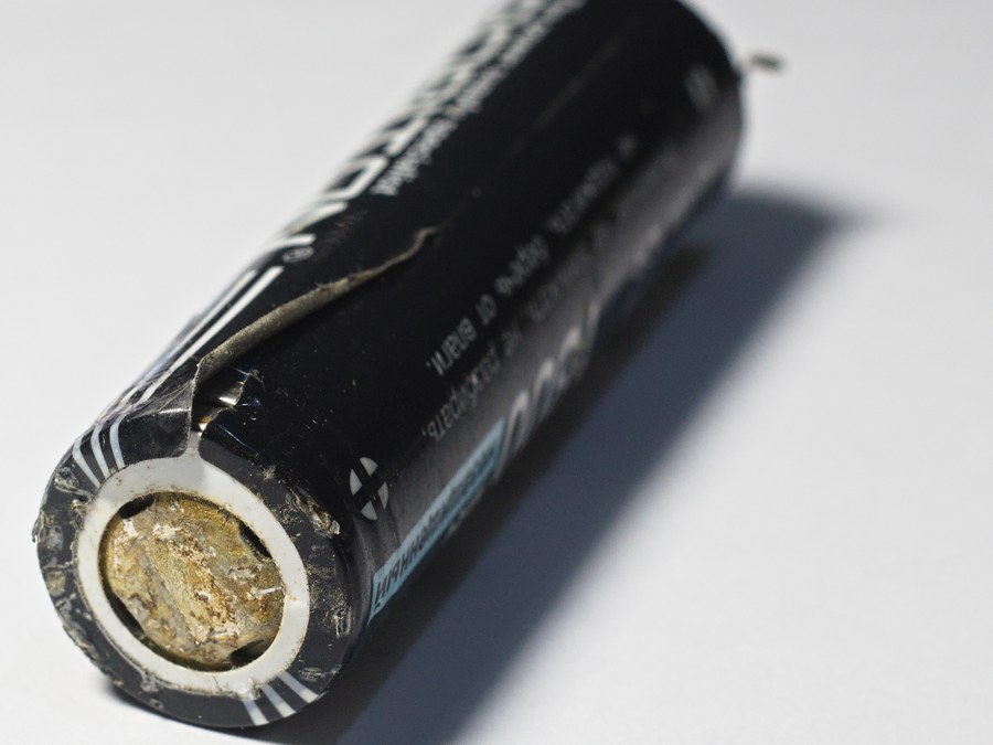Corroded negative end of a failed five-year-old cylindrical lithium ion cell with a split wrapper