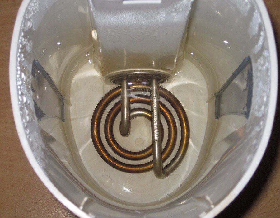 The spiral heating element in the base of an electric kettle, seen from above through the open lid