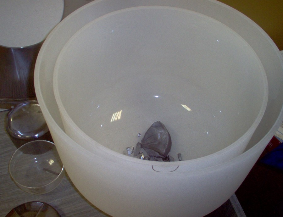 A used fused quartz crucible from a Czochralski crystal puller, with residual solidified silicon in the bottom