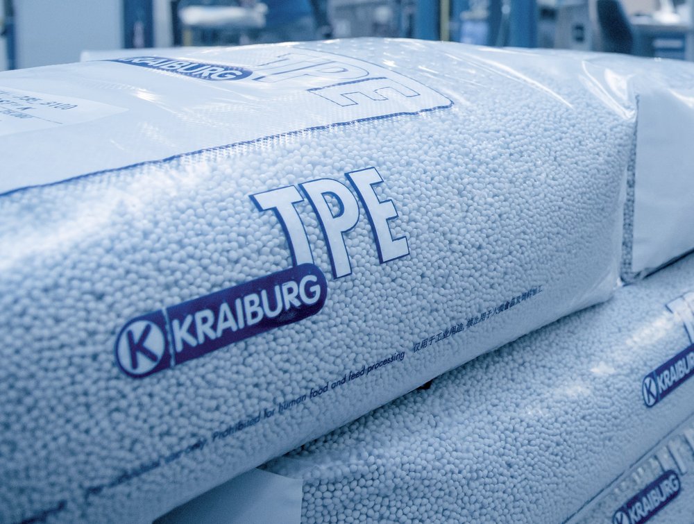 Sacks of white TPE plastic pellets labelled TPE and KRAIBURG stacked in a factory